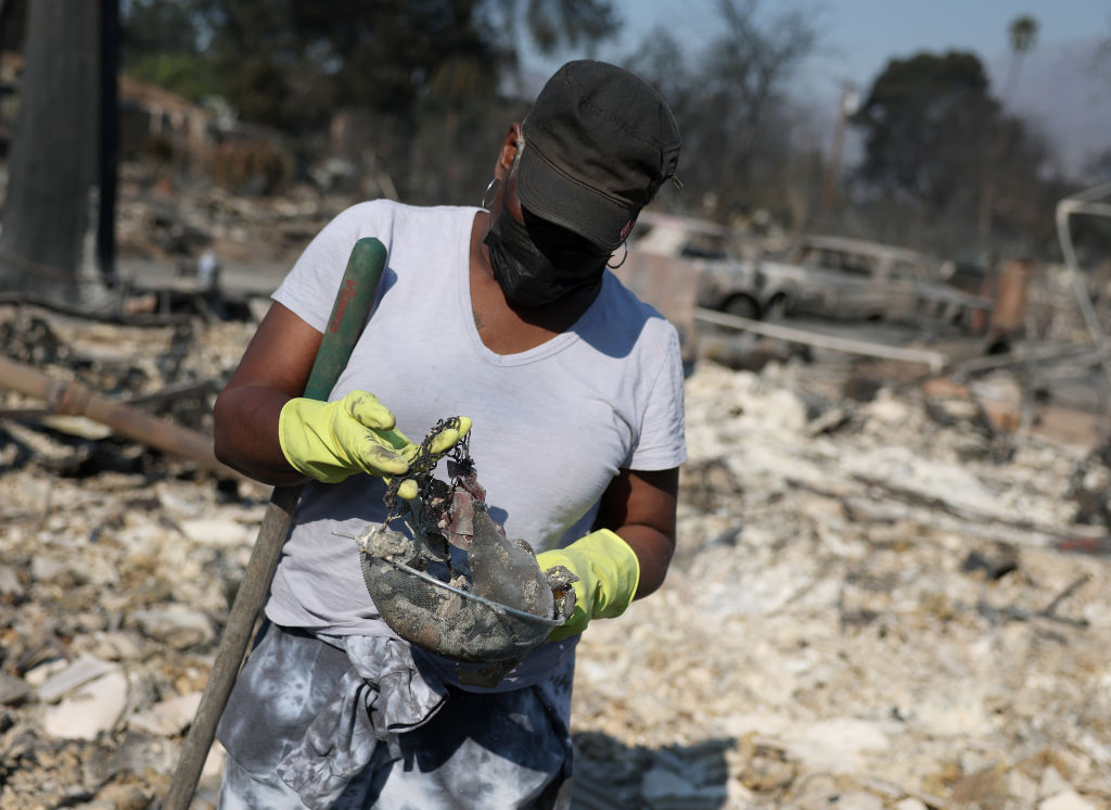 Valerie Robinson inspects burned jewelry she found in the rubble of her family's home that was destroyed by the Eaton Fire on January 10, 2025 in Altadena, California. Fueled by intense Santa Ana Winds, the Eaton Fire has grown to over 13,000 acres and has destroyed over 5,000 homes and businesses. Five people have lost their lives in the fire.